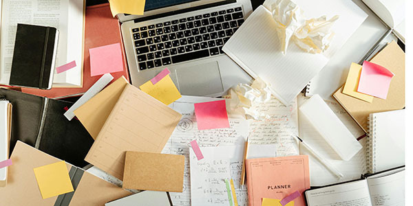 Beeld van bureau met boeken, notities, laptop etc. 