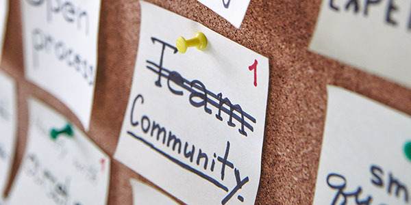 Afbeelding van prikbord met daarop een briefje 'community' Afbeelding van prikbord met daarop een briefje 'community'